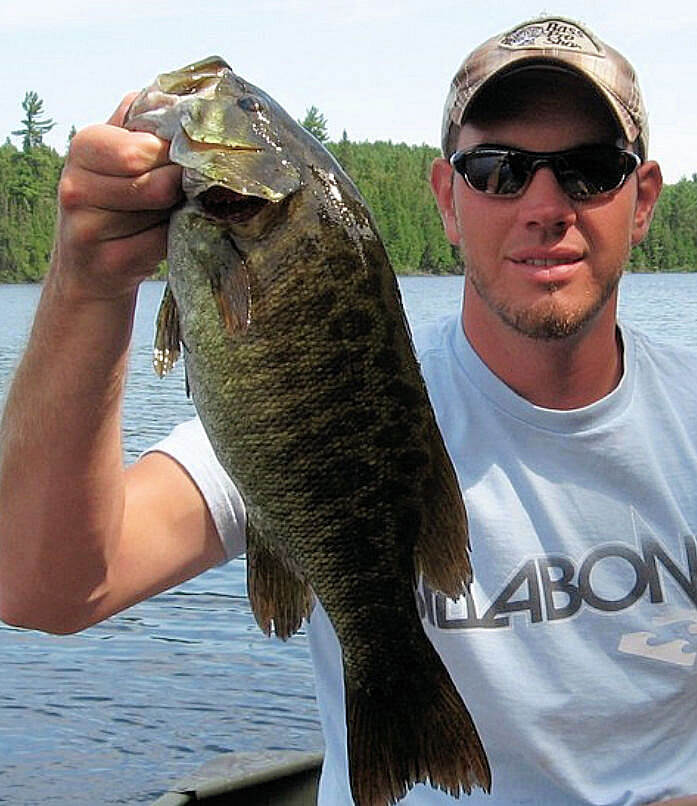 Successful Lady Evelyn angler holding beautifully colored trophy Ontario smallmouth bass.