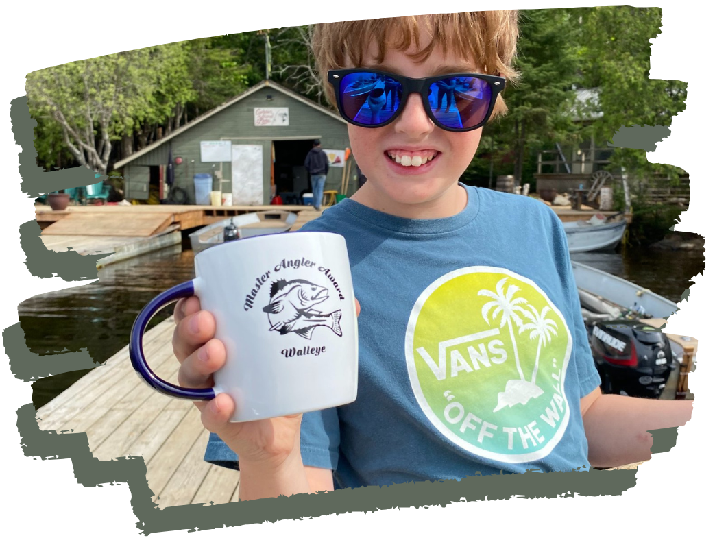 Young smiling angler displays his master angler award mug.