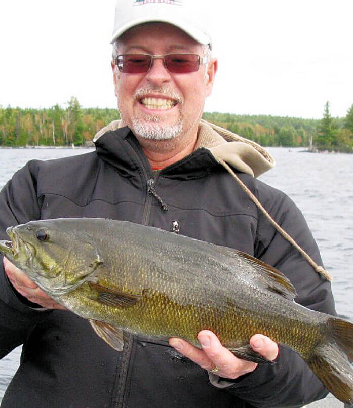 Angler holding beautifully colored trophy Ontario smallmouth bass.