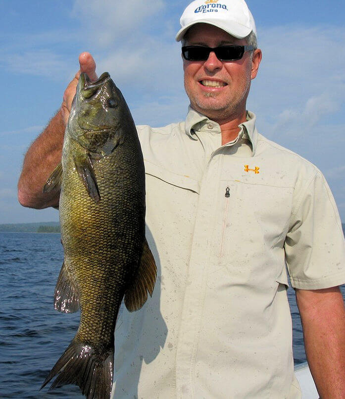 Angler holding beautifully colored trophy Ontario smallmouth bass.